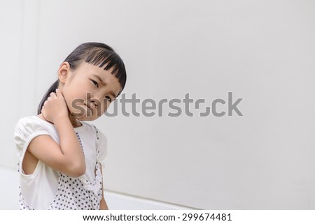 Kid on neckacke pose and pain mood with grey background