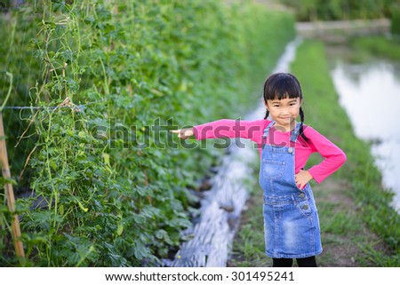 Little girl point to the product in the garden