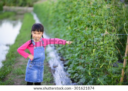 Little girl point to the product in the garden