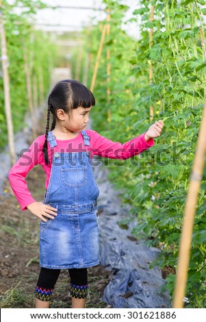 Little girl check product in the garden after plantation for one month