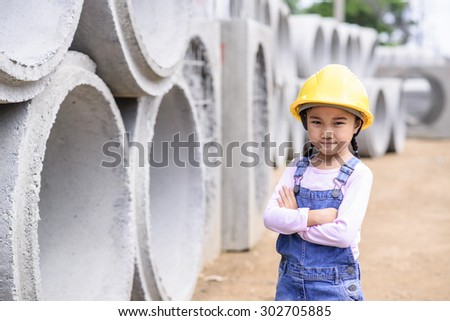 Kid civil engineer inspecting  huge concrete pipe