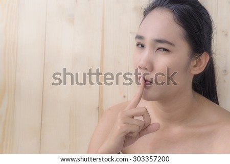 woman portrait use hand touch her mouth with blur wood texture background