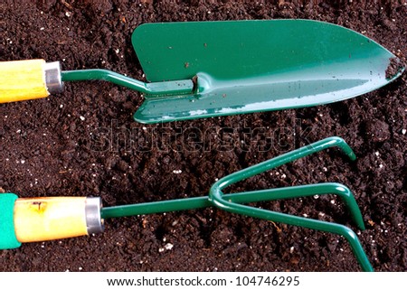 Garden tool with heap of organic compost background