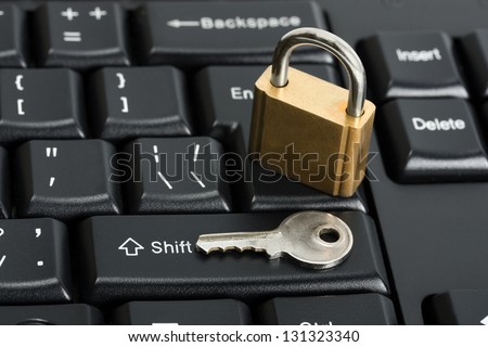 Padlock on the computer keyboard. Safety concept with key