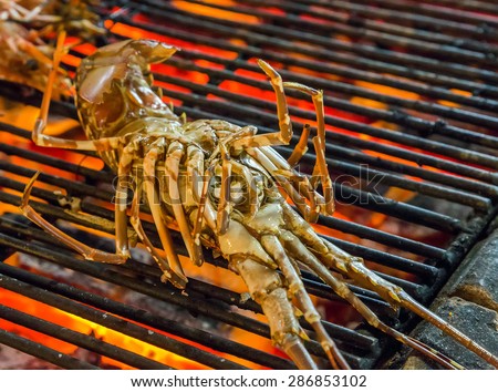 cooked lobster seafood by fire and BBQ Flames. Restaurant Barbecue at the night market