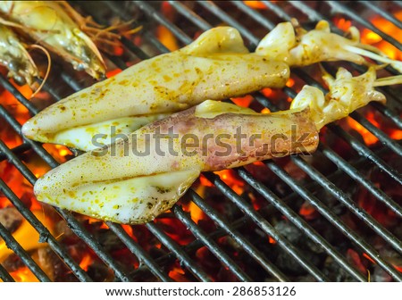 Fresh squid seafood by fire and BBQ Flames. Restaurant Barbecue at the night market