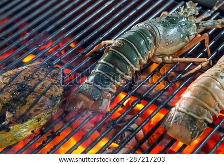 Lobster on the grill seafood by fire and BBQ Flames. Restaurant Barbecue at the night market