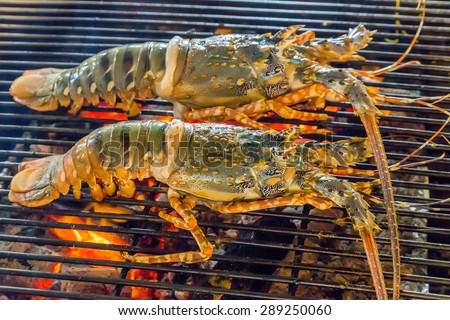 lobster dinner at the restaurant seafood by fire and BBQ Flames. Restaurant Barbecue at the night market