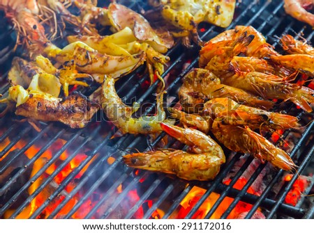 prepared shrimp, prawn grilled barbecued mixed seafood in BBQ Flames.