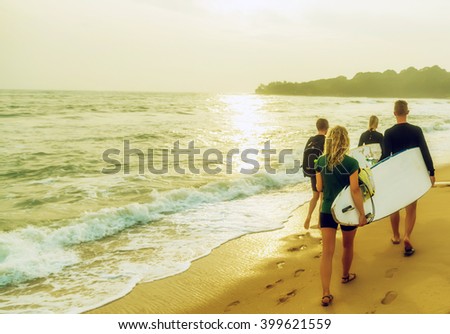 beach surfers running into the sea with surf boards