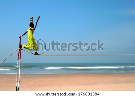 GOA, INDIA - FEB 12: Wandering indian tightrope walker playing on the beach of Goa, on Feb 12, 2008. Small groups of buskers traveling along the coast and arrange free shows for tourists on the beach