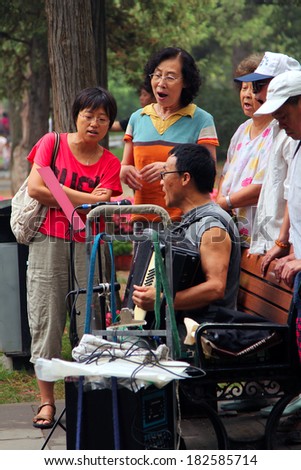 BEIJING, CHINA - JUL 17, 2011: . Women and men are singing in Jingshan park, near Forbidden City. It\'s a popular tradition among the Chinese people to engage in traditional arts outdoors