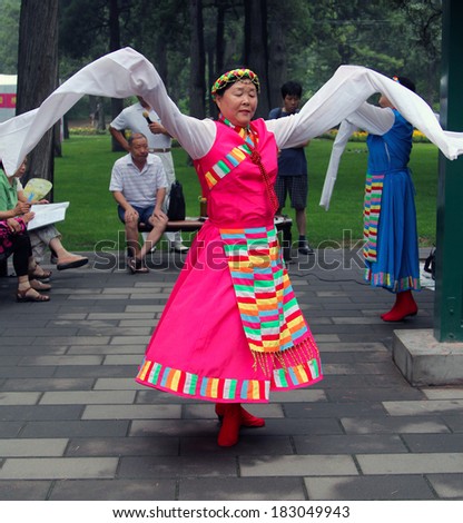 BEIJING, CHINA - JUL 17, 2011: Women are dancing in national costumes in Jingshan park. It s a popular tradition among the Chinese to engage in traditional arts outdoors