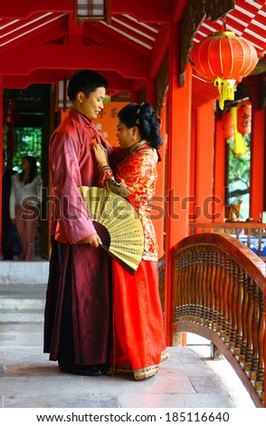GUILIN, CHINA - NOV 4, 2007: Young couple in traditional Chinese costumes. Red is the main color of the traditional festive (including wedding) attire in China