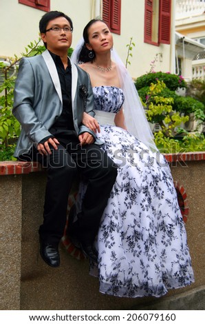 GULANGYU, CHINA - OCT 20, 2009: Young couple posing for wedding portfolio. Picturesque streets of the Gulangyu island are very popular among honeymooners