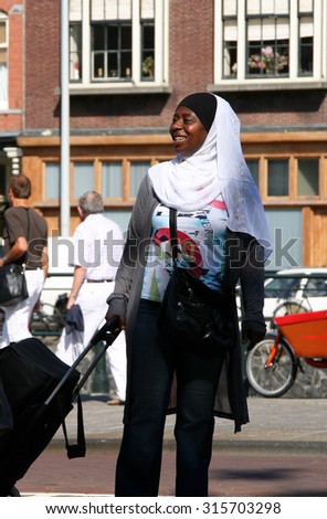 AMSTERDAM, NETHERLANDS - JUL 4, 2009: Smiling woman in the street. Amsterdam is one of the most multicultural capitals Europe, is home to 200 different nationalities