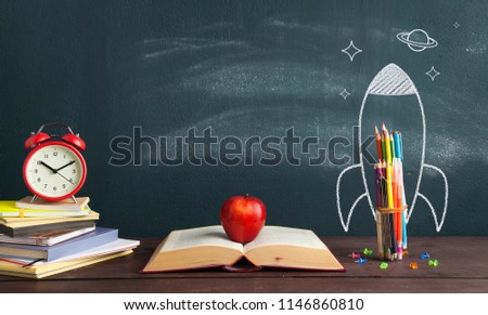 Back to school banner. Rocket sketch and open book in front of blackboard