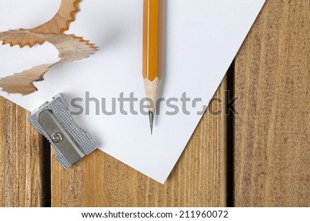 Directly above view of a old wooden table , papers, a pen and pencil sharpener on it. Close up shot.