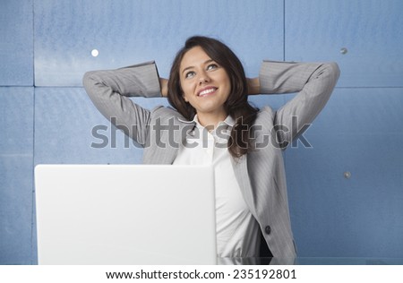 Businesswoman relaxing with hands behind head
