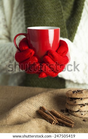 Closeup of a hands in gloves with hot drink