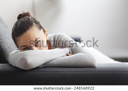 Stressed young housewife in living room