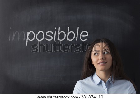 Business woman looking left side and thinking turning the word impossible to possible.