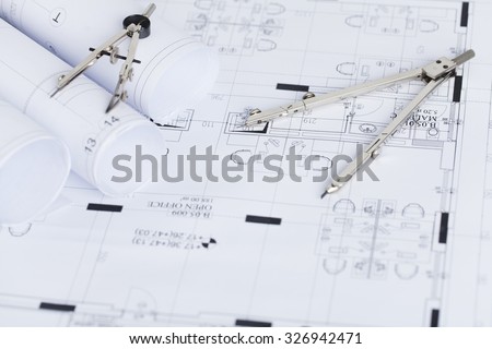 Construction planning drawings on the table and two drawing compasses