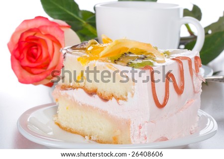 piece of cake with fruits, rose and cup