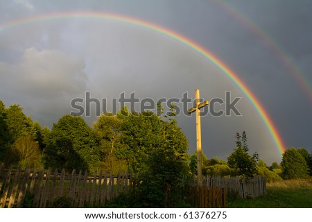 cross and rainbow after summer rain