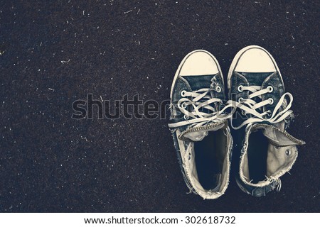 Old & Torn sneakers on Rubber flooring with filter effect retro vintage style  ,Background layout with free text space.