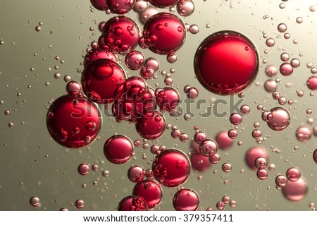 Many red fizz bubbles float over a dark background