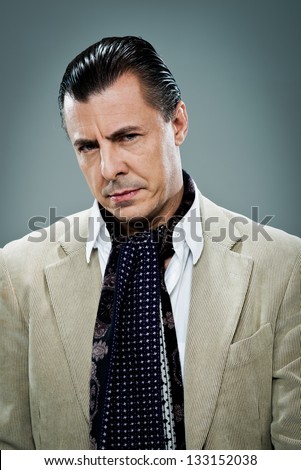 Mature Man with Serious Expression Over a Grey Background