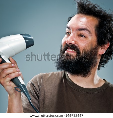 Young Happy Man with an Hair Dryer Over a Grey Background