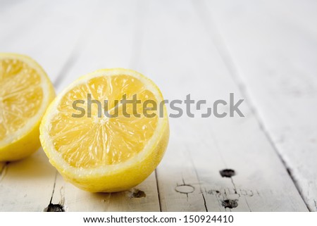 Extreme close up of a lemon cut in half on a white aged table with copy space on the right