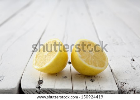 Lemon halves giving himself back on a white aged table with copy space on top