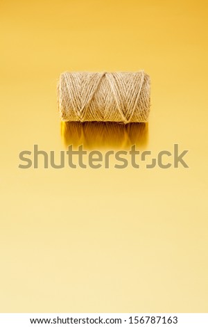 Roll of cord on a golden reflective surface with copy space