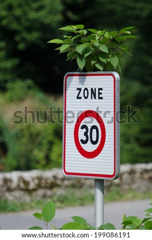 road sign with a green plan growing from it