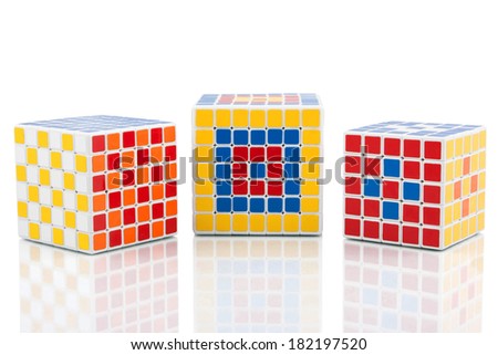 KRAGUJEVAC, SERBIA - MARCH 8, 2014: Three puzzle cubes on the white background. Rubik\'s Cube invented by a Hungarian architect Erno Rubik has many different variations.