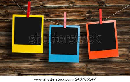 Color frames in polaroid style on wooden background