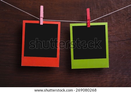 Color frames in polaroid style in front of wooden background