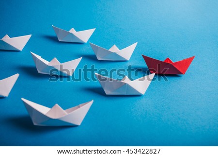 Red paper leader ship with fleet. Concept for leadership, management, motivation, difference and uniqueness.