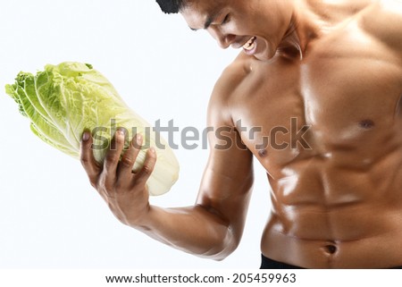 A muscular guy and fresh vegetable ,shaped abdominal, isolated on white background