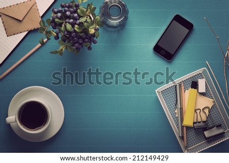 Office workplace,office Equipment and coffee break on blue crepe paper desk,vintage