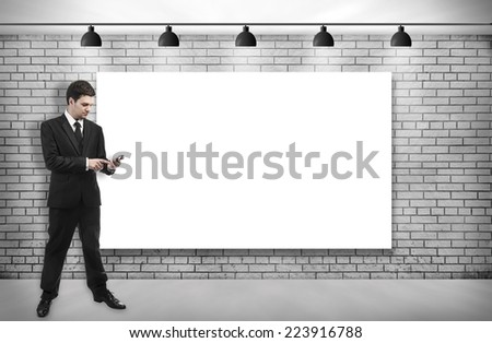 businessman holding smartphone with Blank frame on brick room