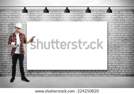 construction worker and Blank frame on White Brick wall with Ceiling lamp
