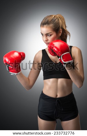 beautiful woman in red boxing gloves on gray background with clipping path
