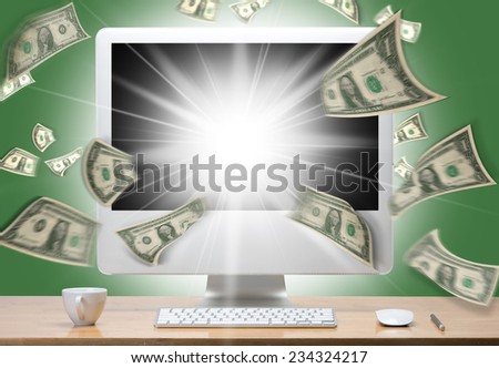 computer monitor and dollars. Money taking off from the screen