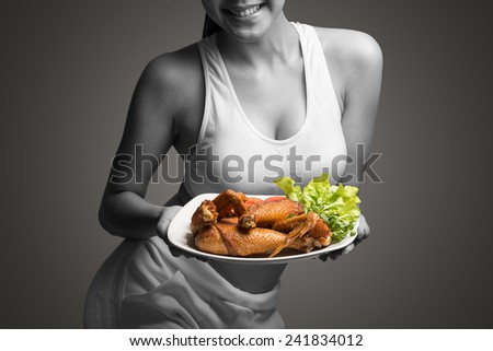 Young woman with perfect body holding and showing roast chicken for delicious menu,healthy food - healthy lifestyle concept