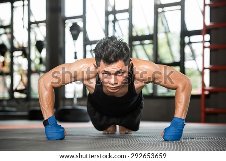 Attractive muscular man doing push-ups on gym floor