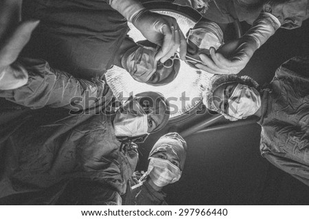 Surgeons team standing above of the patient before surgery. , Black and white,noise and film grain style
